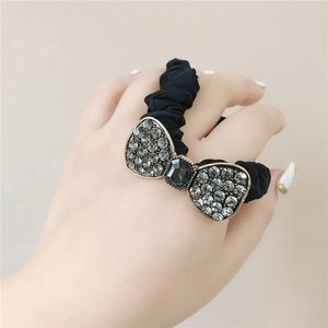 Detail of black bow hair tie with sparkling rhinestones and a dark gray crystal centerpiece