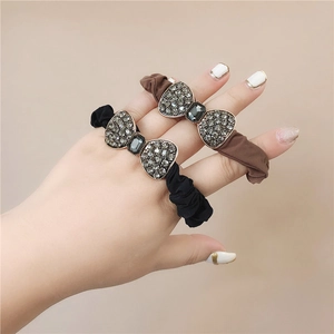 Detail view of high elasticity hair ties with rhinestone bows in black and brown