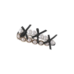 Close-up of vintage black silk bows and white heart-shaped pearls on a metal hair clip