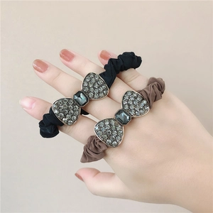 Detailed view of elastic hair ties with sparkling rhinestone bows in black and brown