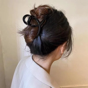 Pince à cheveux noire minimaliste sur un modèle pour une coiffure relevée élégante