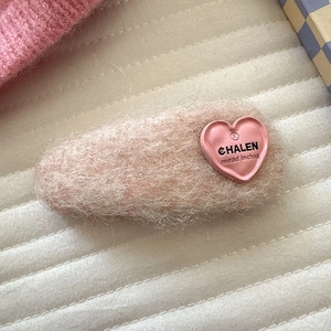 Nahaufnahme der rosa flauschigen Haarspange mit Plüschtextur und Herzverzierung