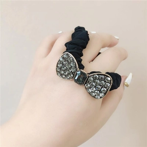 Elegant black scrunchie with crystal butterfly accent shown on wrist for daily hair styling
