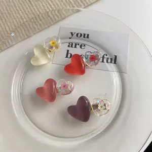 Vue détaillée de barrettes à cheveux coeur en résine avec fleurs séchées sur plateau