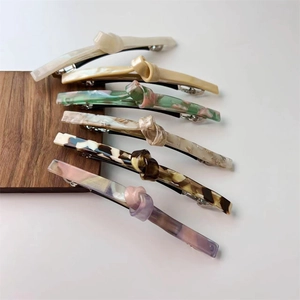 Detail view of colorful twist knot hair clips with marble and acetate texture