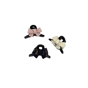 Three mini acrylic bow hair claws in pink, cream white, and black for daily hair styling