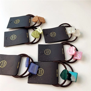 Detail of geometric heart and square hair ties with faux marble finish on display card