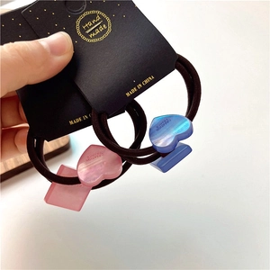 Macro detail of geometric heart resin hair ties with gradient pink and blue finishes