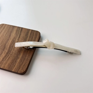 Close-up of cream twisted resin hair clip with durable silver metal spring buckle