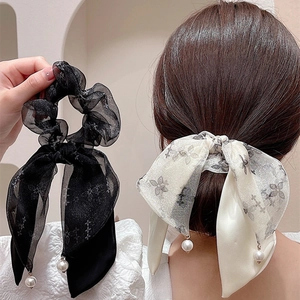 Dettaglio elastico per capelli con fiocco in tulle, stampa a farfalla e perla