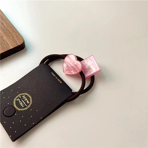 Detailed macro view of pink resin heart and square charms on high elastic hair tie