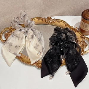 Dettaglio ravvicinato di elastici in rete con stampe floreali e ciondoli di perle eleganti