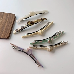 Detail view of colorful twist knot hair clips with multiple patterns in a set of six