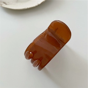 Macro shot of translucent brown resin hair claw clip with sleek rectangular design