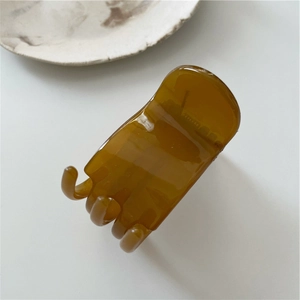 Detail of a transparent amber hair claw clip with smooth polished resin teeth