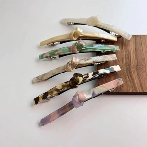 Japanese knot twist spring hair clips in six assorted acetate colors on wooden display
