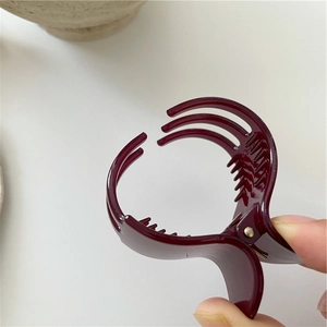 Detail showing high-gloss wine red shark hair clip with non-slip metal spring teeth