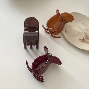 Detail of high-quality acrylic hair claws in dark coffee, amber, and burgundy shades