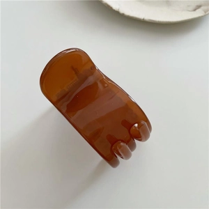 Minimalistische haarklem van amberhars met transparante afwerking op witte achtergrond