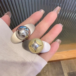 Detailed macro of gold and silver teardrop hair clips with engraved star motif