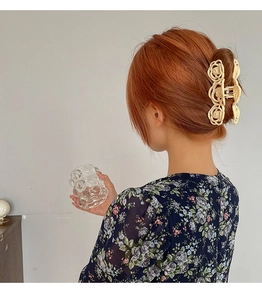 Close-up of cream camellia hair claw clip on model's head showing elegant flower design