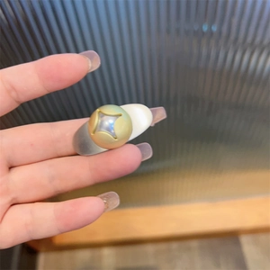 Close-up of dual-tone metal teardrop hair clip with a gold star-engraved center sphere