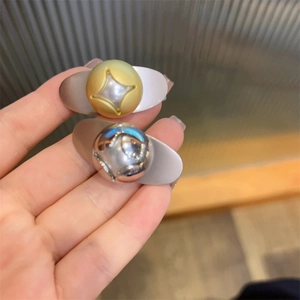 Detailed view of dual-tone gold and silver teardrop hair clips with star engraving