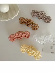 Close-up detail of five elegant matte and transparent rose flower hair claws for women