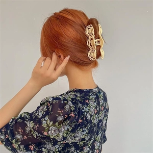 Elegant cream rose cutout hair claw clip for women shown on back of head
