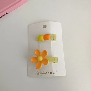 Detail view of Korean style floral hair clips with orange flower and candy color beads