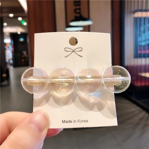 Dettaglio del fermaglio per capelli coreano con quattro perle color ambra su una base d'oro