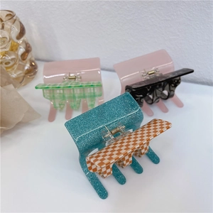 Detail showing various acetate shark hair claw clips in checkered and marble patterns
