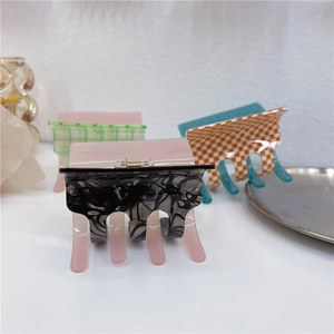 Detail of diverse large acetate hair claws featuring checkerboard and marble patterns