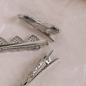 Détails de barrettes argentées en forme de cœur serties de strass brillants en métal