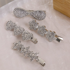 Détail de barrettes argentées serties de strass étincelants en formes de cœur et d'étoile