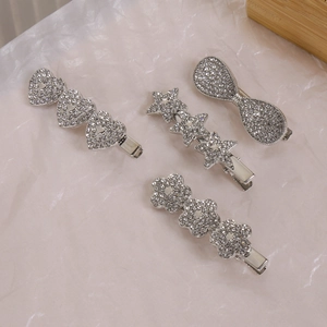 Détail de barrettes Y2K ornées de strass étincelants en formes de cœur, d'étoile et de nœud