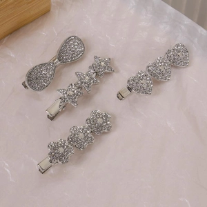 Set de barrettes Y2K argentées avec étoiles et cœurs en strass sur fond blanc