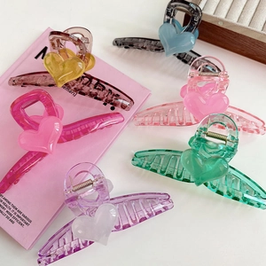 Close-up of colorful heart-shaped hair claws made of translucent resin with metal springs