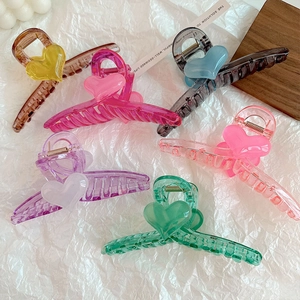 Detail showing six colors of heart-shaped large hair claw clips made of translucent resin