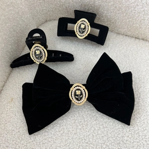 Detail view of black velvet hair clips with vintage rose and pearl embellishments