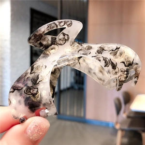 Macro shot of large acetate hair claw clip featuring black and white marble leopard pattern