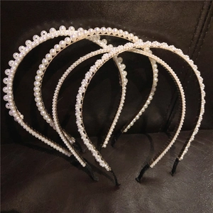Vue détaillée de quatre serre-têtes en perles blanches aux tailles et motifs tressés variés