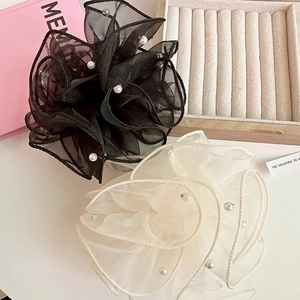 Détails de grands chouchous en organza noir et beige avec d'élégantes perles d'imitation