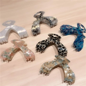 Set of large acetate hair claws in various leopard and marble patterns on wooden surface