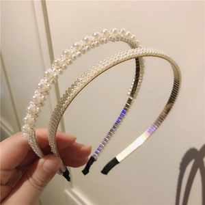 Gros plan de deux serre-têtes en perles faits main avec divers motifs de perles blanches