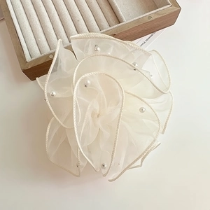 Détail d'un chouchou en organza blanc avec des perles élégantes et texture plissée