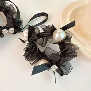 Detail of black mesh hair scrunchies with white pearls and heart rhinestone bows