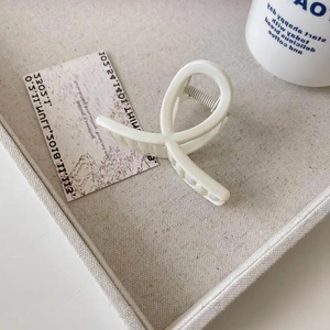 Pince à cheveux blanc ivoire mat avec un design torsadé géométrique minimaliste