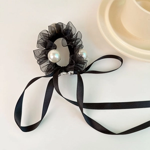 Detail of black organza scrunchie with large pearls, rhinestones and long satin ribbon