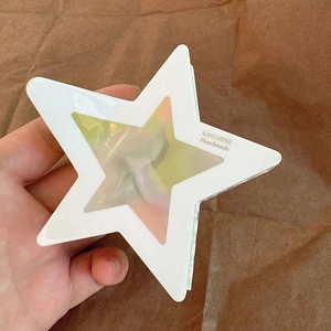 Dettaglio della pinza per capelli a forma di stella bianco crema con centro iridescente
